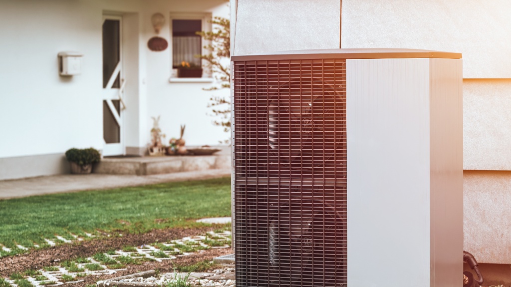 An air conditioner outdoor unit outside of a house in the grass