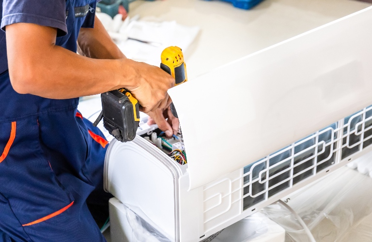 Repairman is fixing air conditioning system
