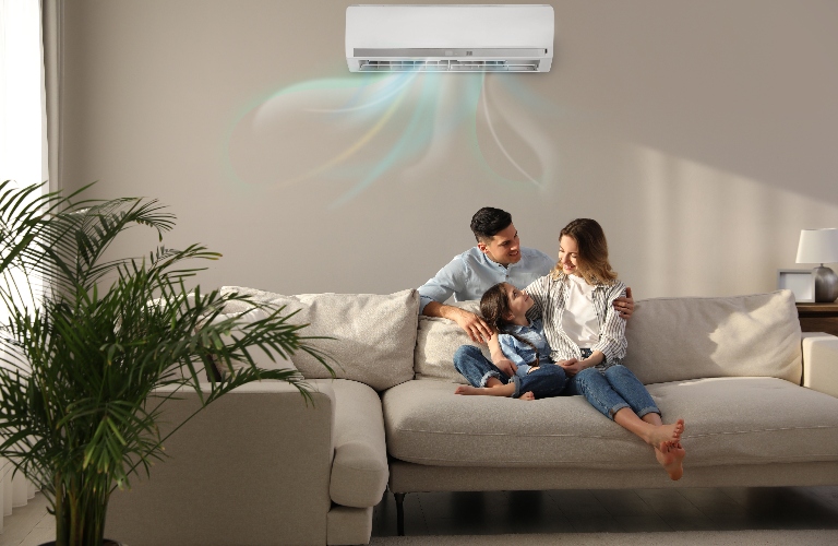 Happy family resting under air conditioner