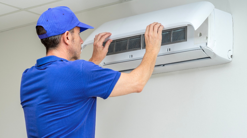 Hvac technician performing air conditioner maintenance inspection