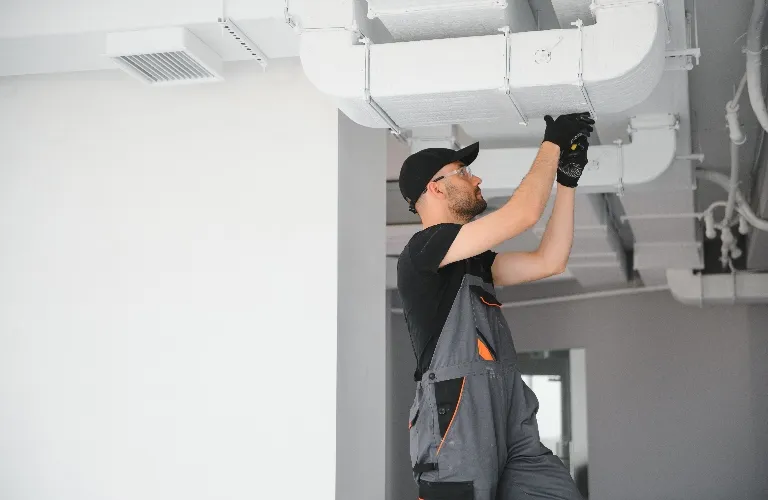 hvac technician adjusting ducts
